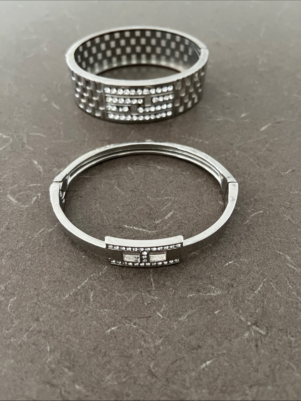 2 Silver tone Cuff Bracelets - one missing stone.